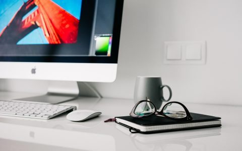 A home office desk with credit card bank statements and a laptop open to a financial spreadsheet.