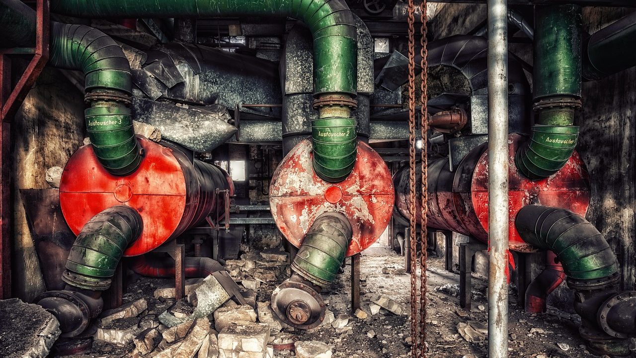 Heating technician inspecting an older residential boiler in a basement.