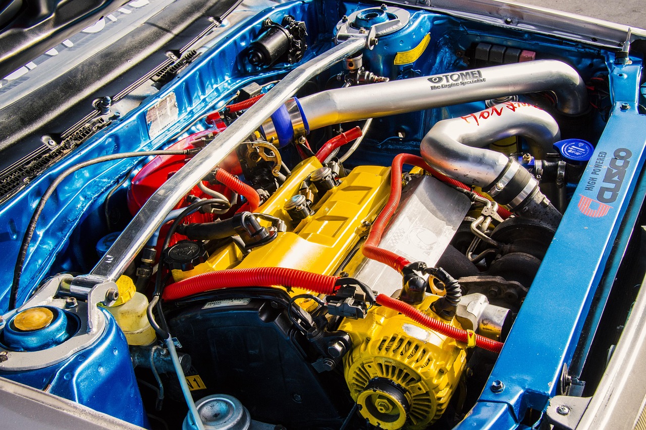 An auto technician examining an engine bay during a vehicle safety inspection.