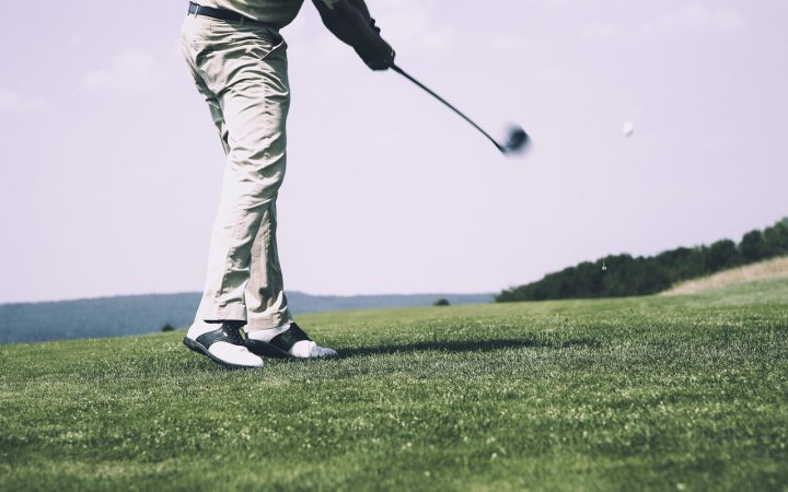 A golfer closely examining the club face of a pre-owned iron.