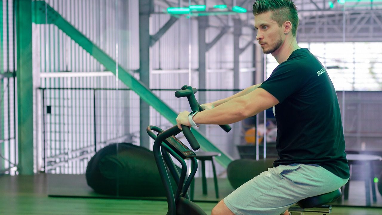 A person riding a stationary fitness bike in a modern home gym.