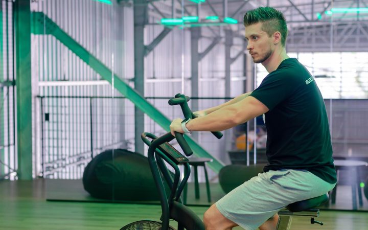 A person riding a stationary fitness bike in a modern home gym.