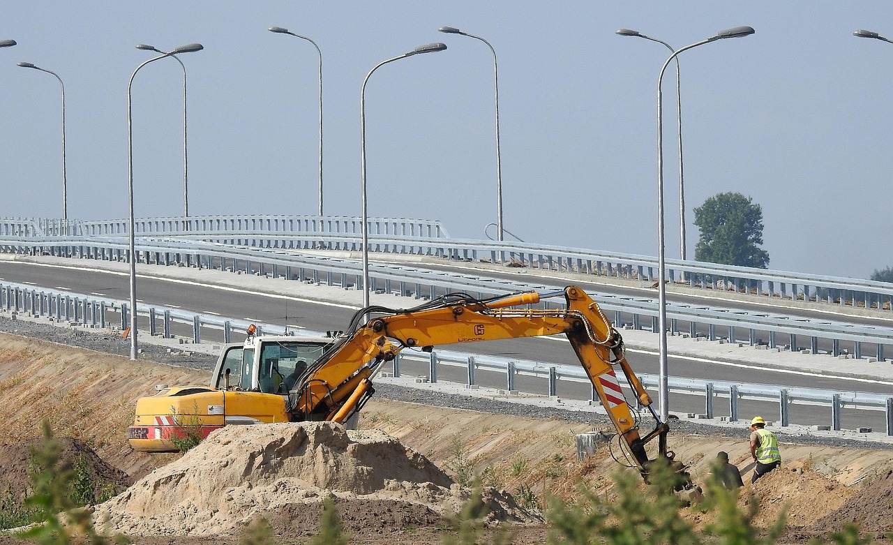 An excavator performing deep excavation work next to a residential foundation.