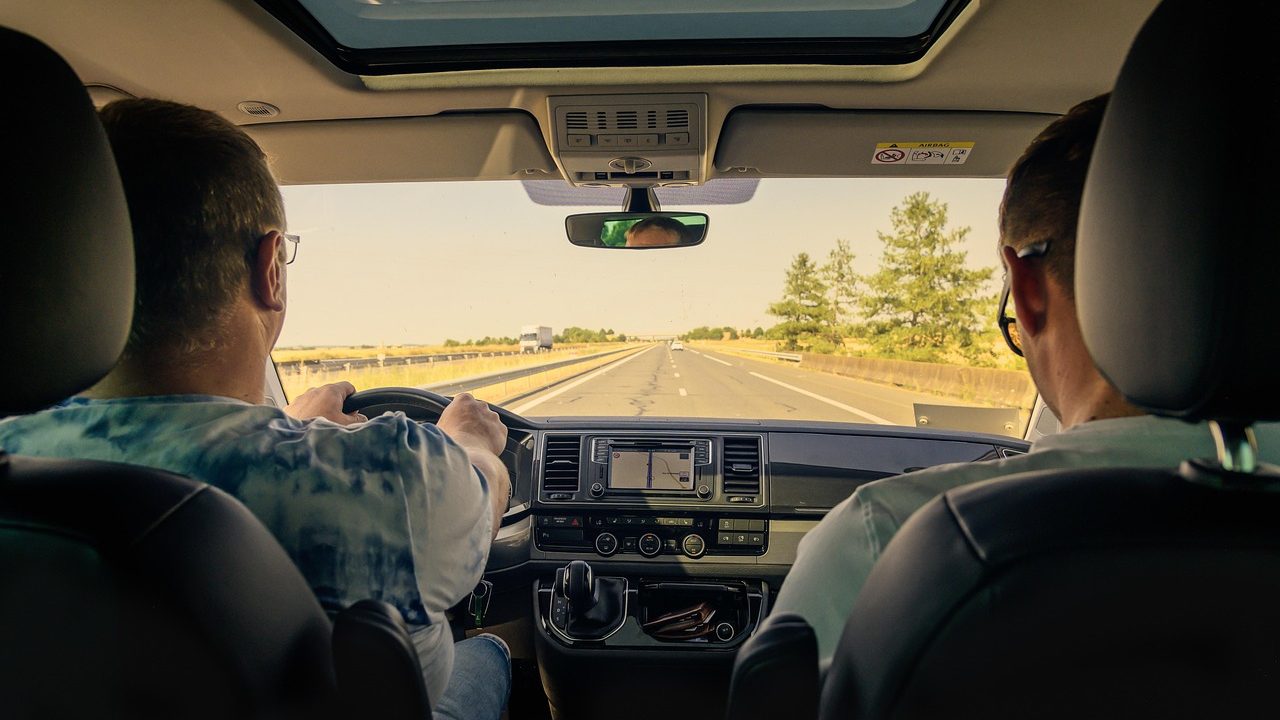 Driver interacting with a modern vehicle touchscreen display.