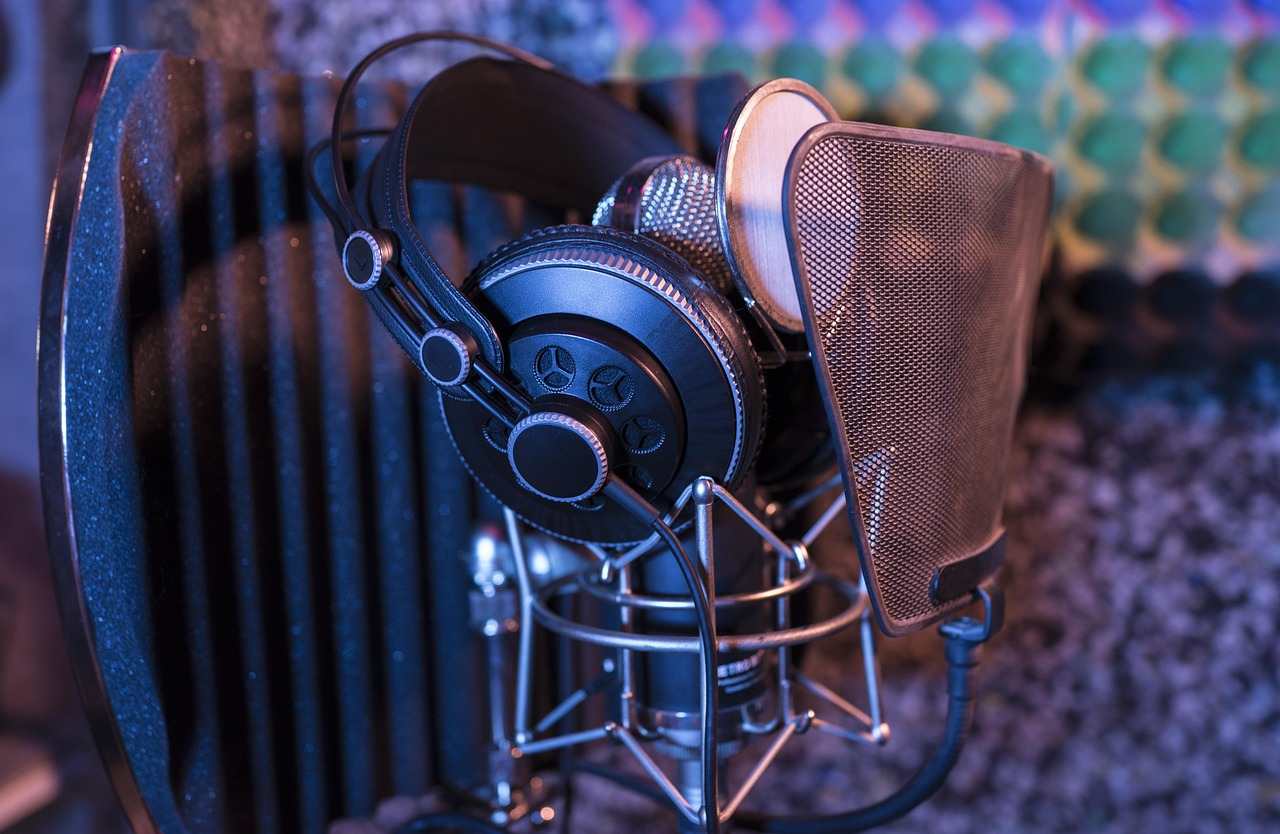 Hands assembling a metal shock mount onto a studio microphone for remote work audio clarity.