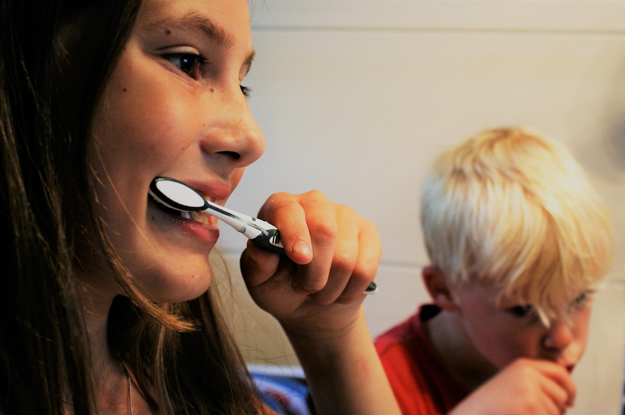 Owner using a finger brush with dog toothpaste on a calm golden retriever