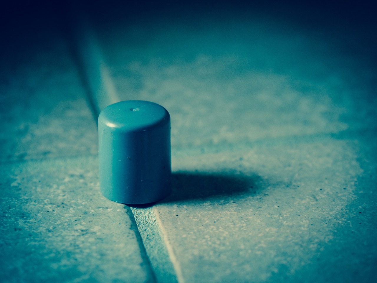 A fabric door draft stopper lying at the base of a hardwood entry door.