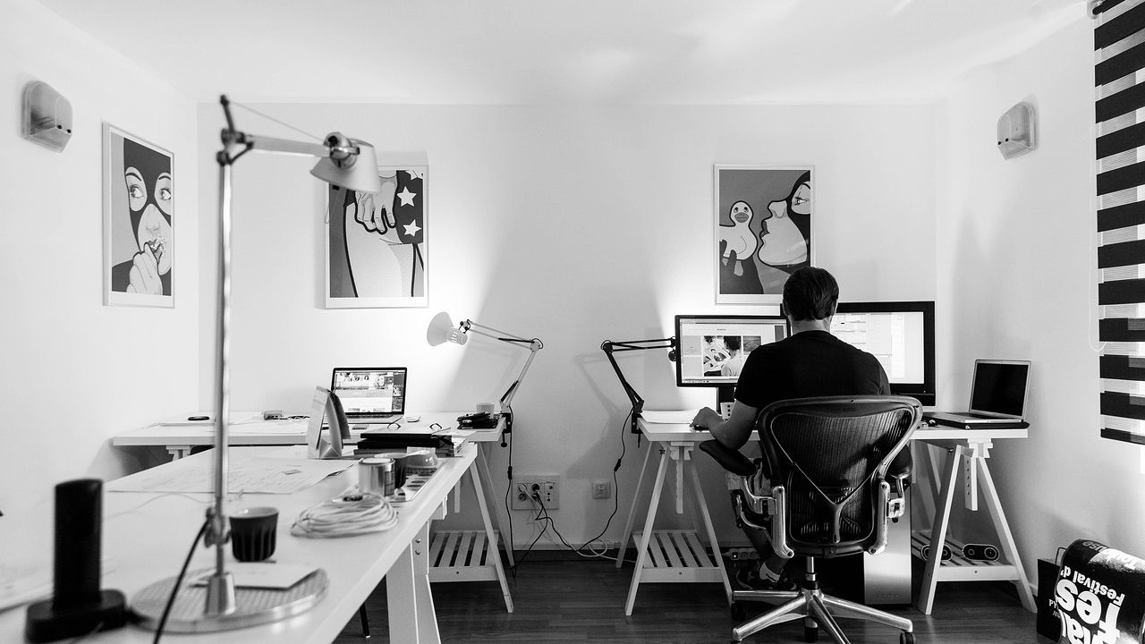 Clean home office desk with dual laptop setup and external monitor