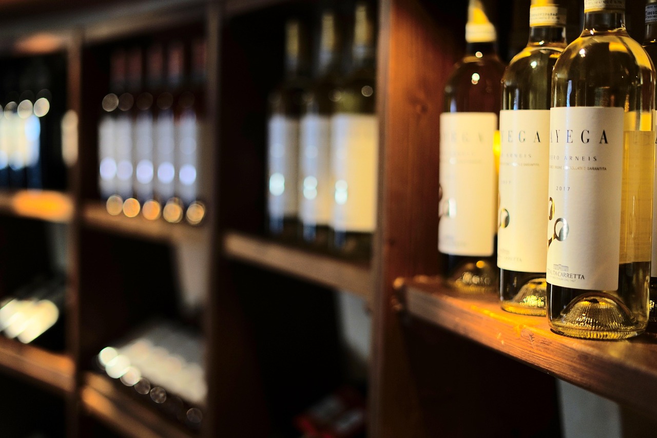 Rows of wine bottles neatly organized on wooden shelves inside a climate-controlled cellar.