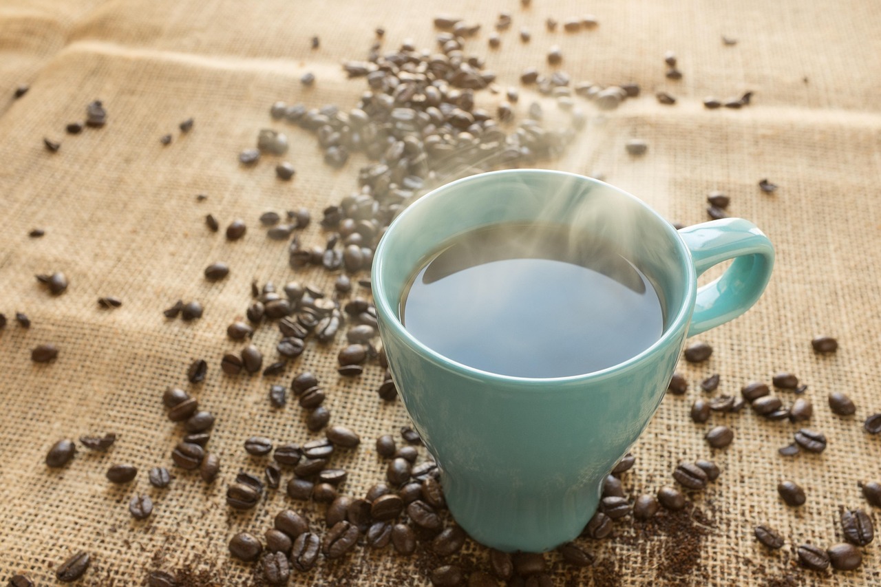 Pouring boiling water from an electric kettle into a ceramic mug.