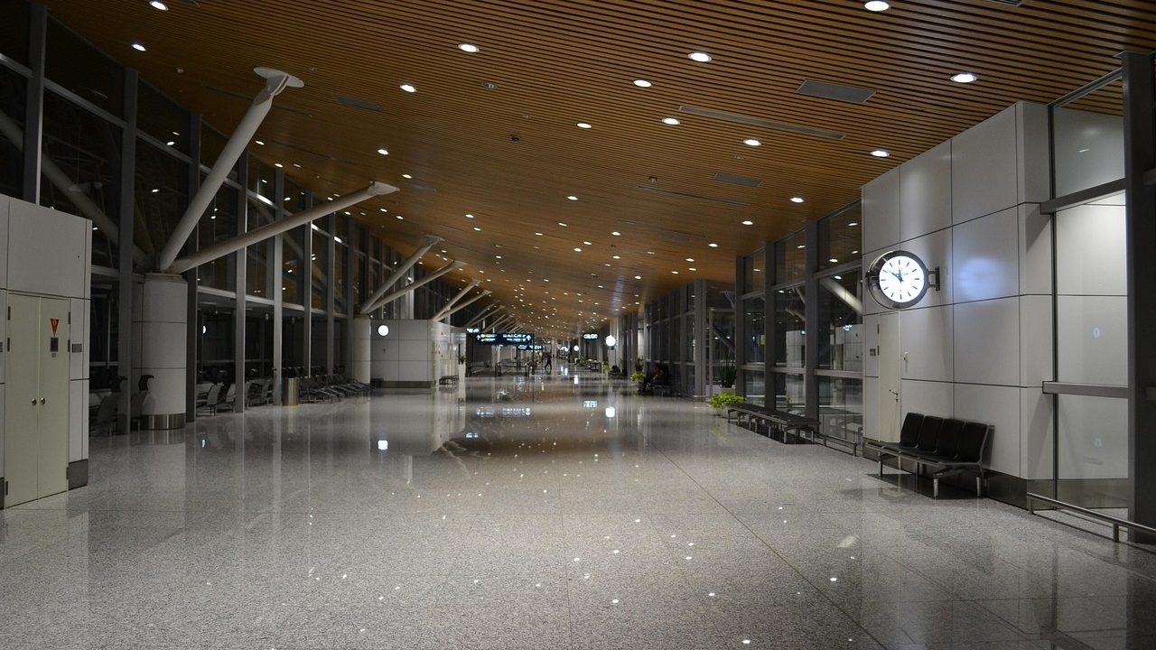 Traveler standing in an airport terminal hallway near security screening checkpoints