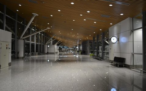 Traveler standing in an airport terminal hallway near security screening checkpoints
