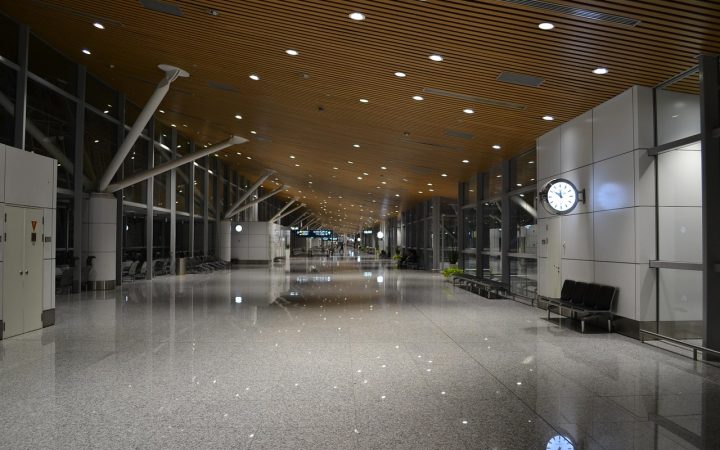 Traveler standing in an airport terminal hallway near security screening checkpoints