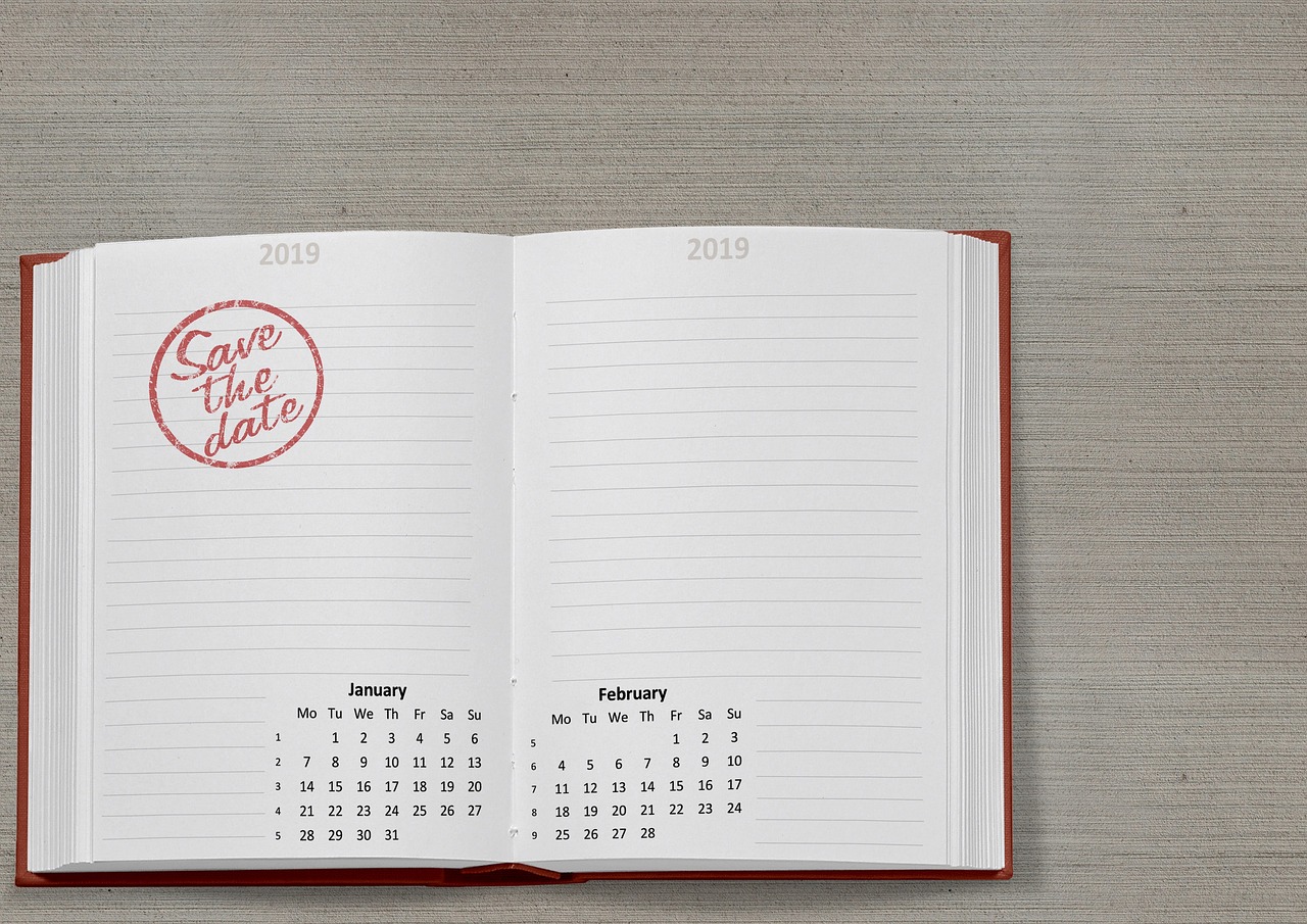 Wall calendar and notes detailing application deadlines on a wooden desk