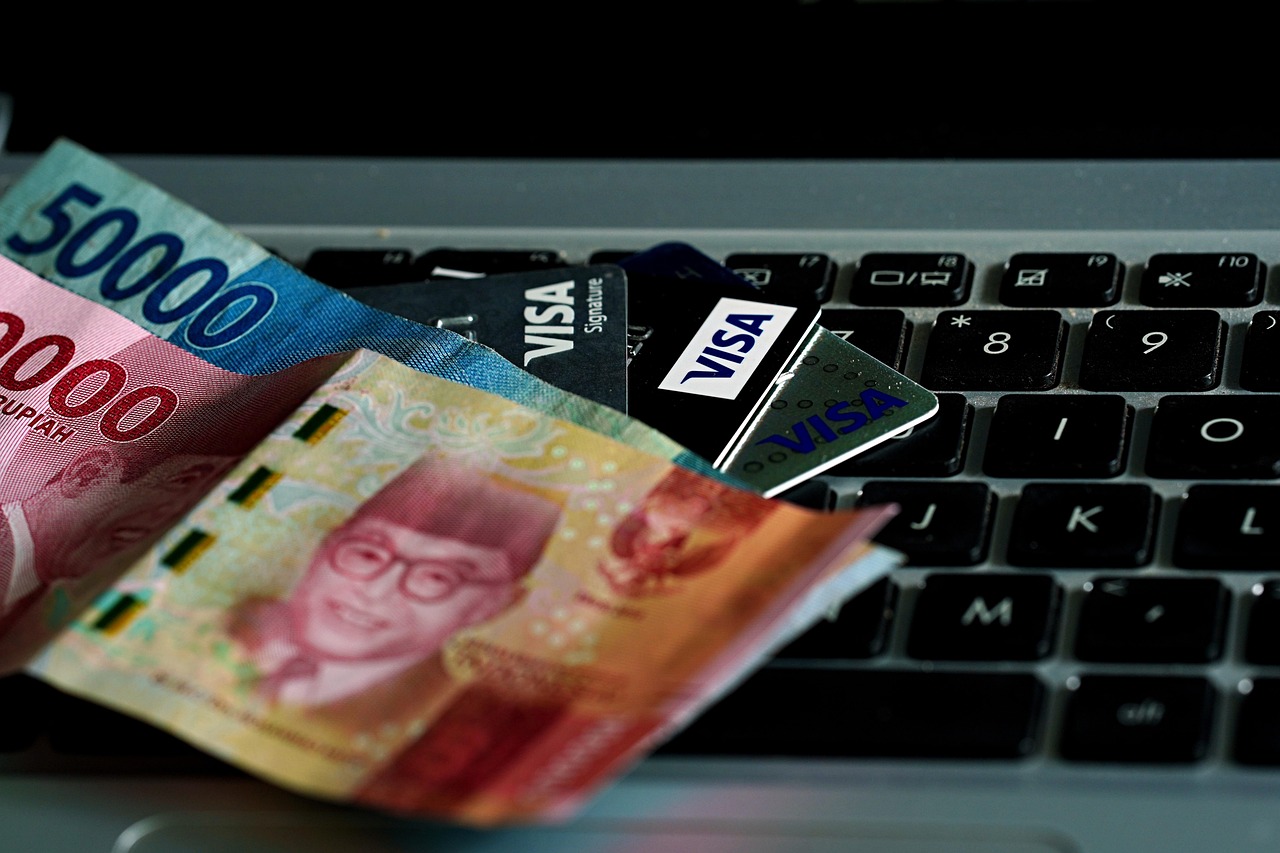 A person holding a debit card and opening a leather wallet.