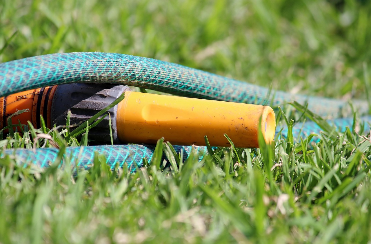 Using a garden hose to flush out a residential gutter downspout