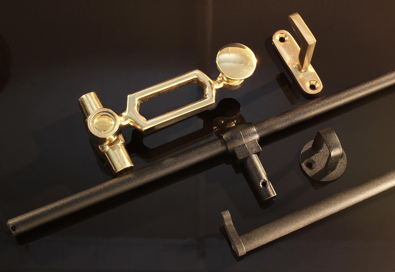 Close-up of a brass window sash lock being tightened into alignment.