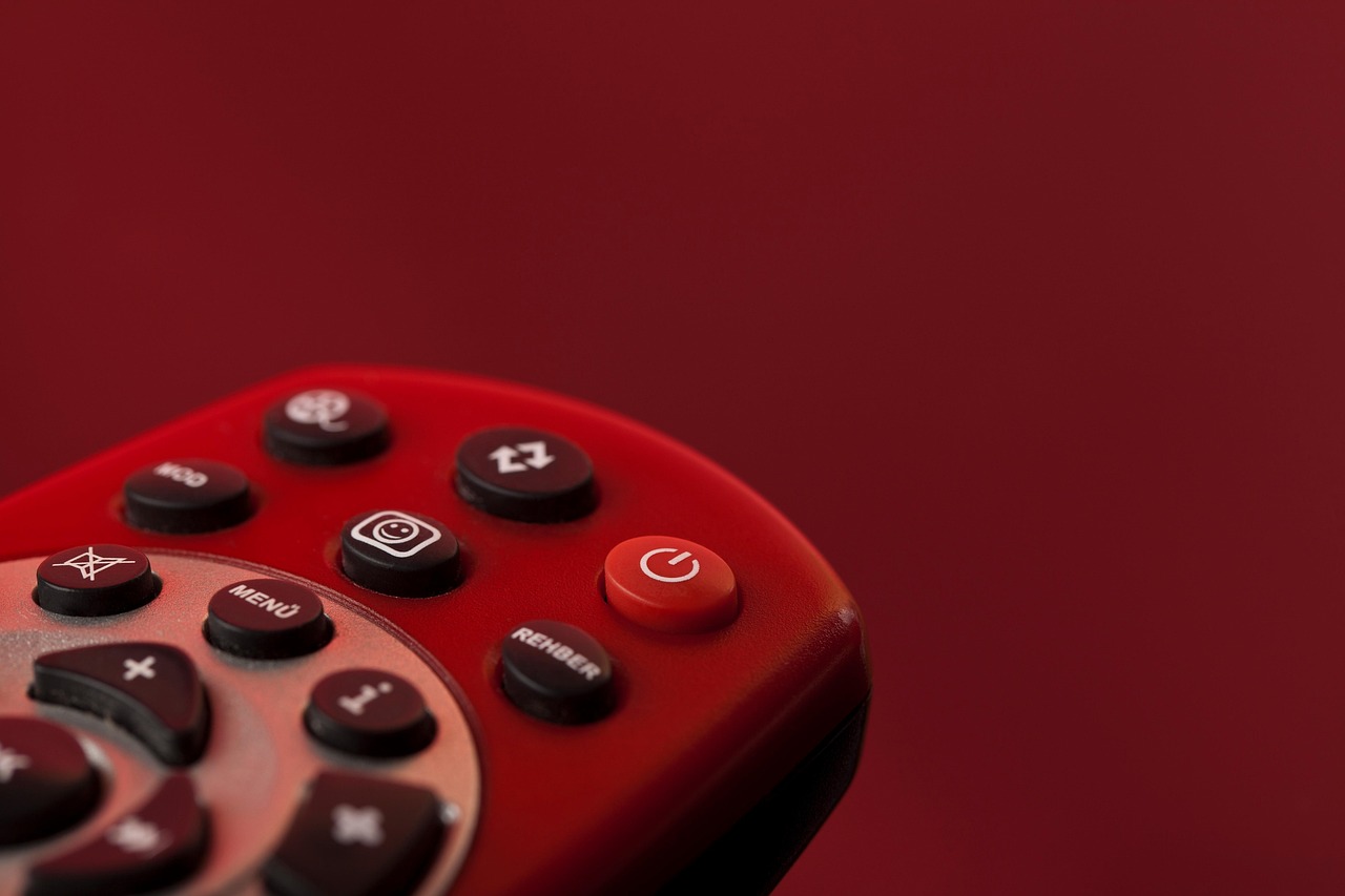 Person using a remote control while watching a living room television.