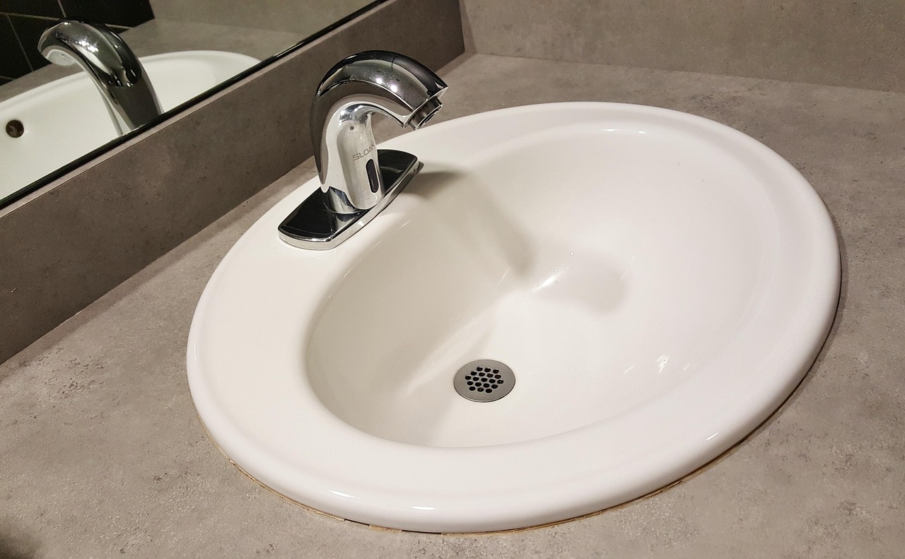 Close-up of PVC P-trap and slip-joint connections under a kitchen sink