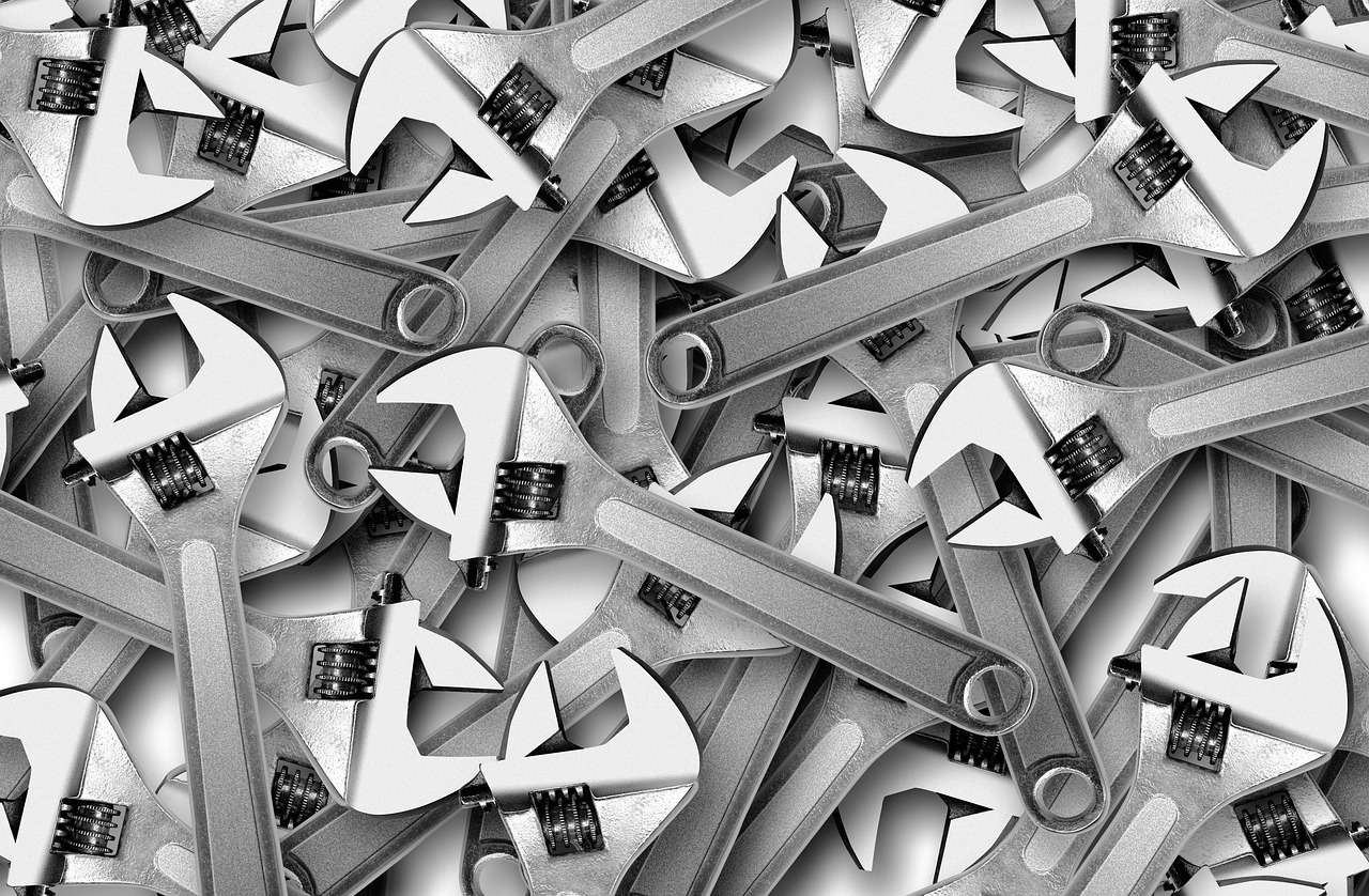 Adjustable wrench and PVC pipe fittings on a workbench