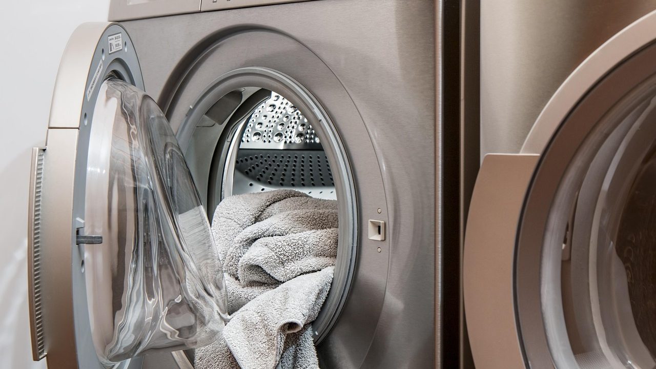 Person folding clean laundry in a modern home laundry room