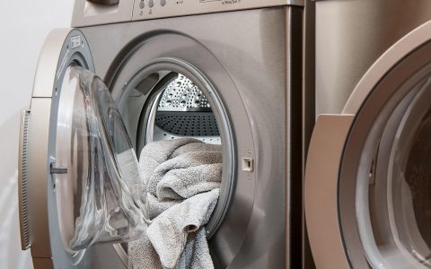 Person folding clean laundry in a modern home laundry room