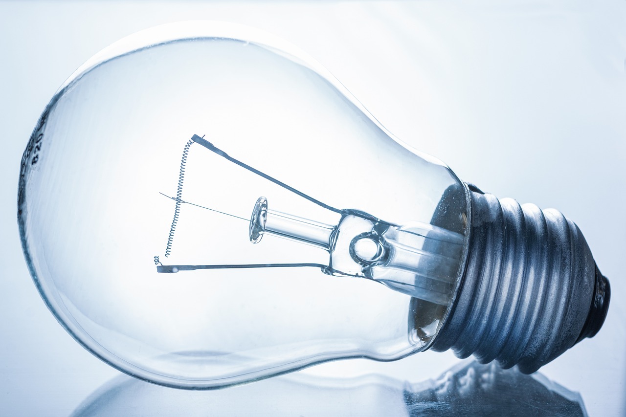 Homeowner comparing traditional incandescent and modern LED light bulbs side by side