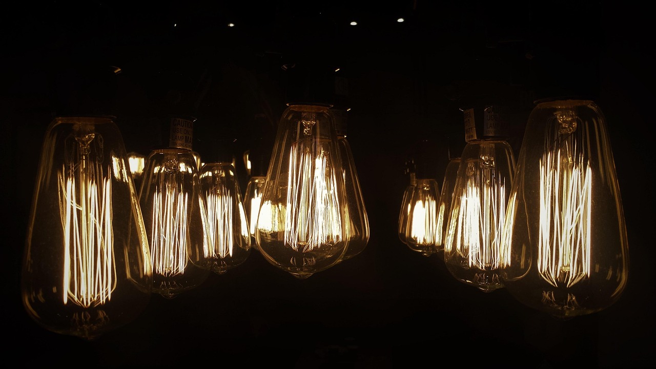 Close-up of a person screwing an LED bulb into a ceiling fixture