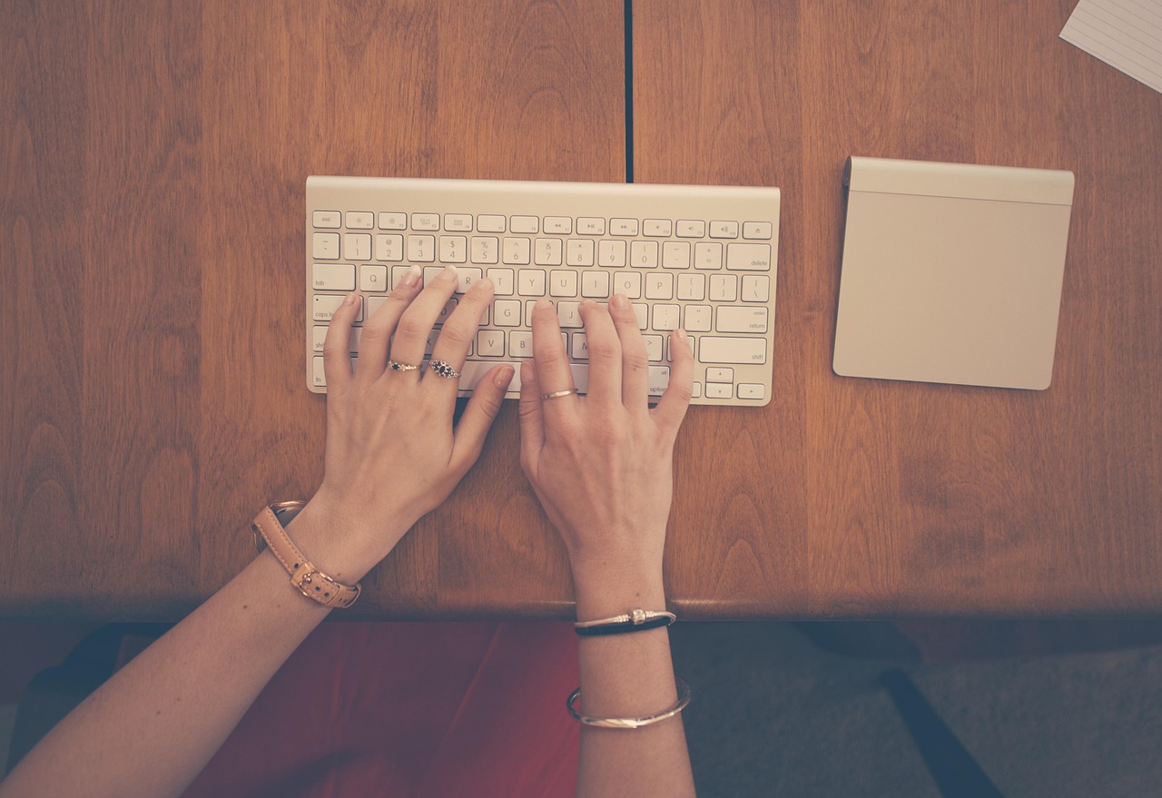 Close-up of hands typing on a laptop keyboard during a focused work session.