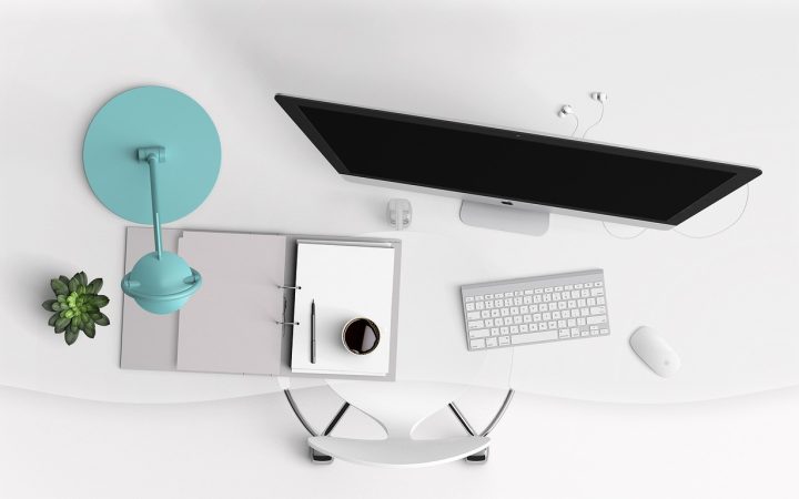 A clean modern home office desk setup illuminated by a sleek monitor light bar mounted above the display.