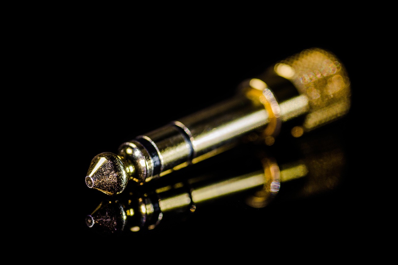 Close-up of hands screwing a brass faucet adapter onto a kitchen sink aerator.