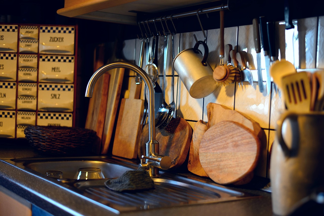 A corrugated gray drainage hose resting securely inside a stainless steel kitchen sink basin.
