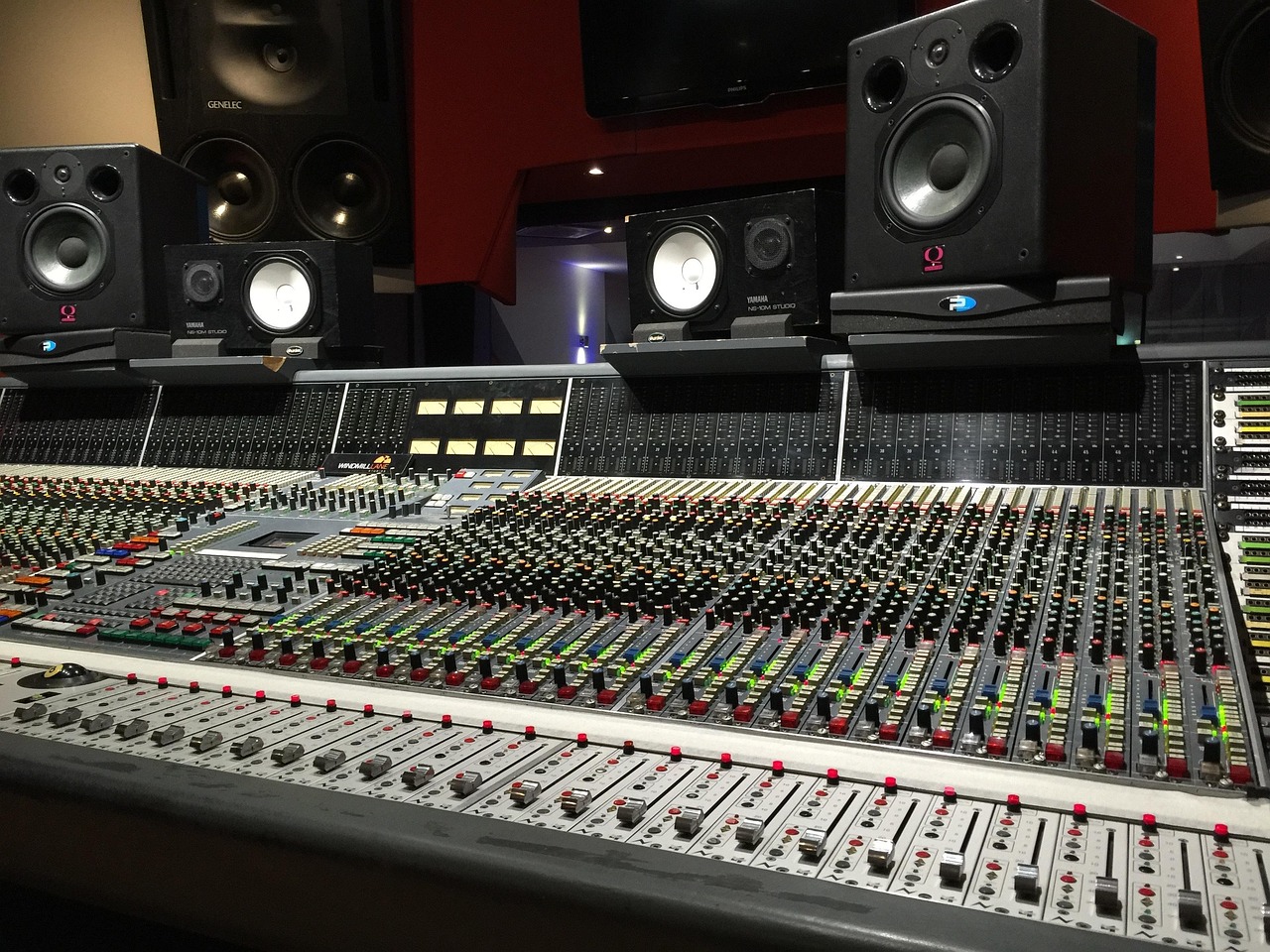 Sound engineer adjusting knobs on a desktop audio interface in a home studio
