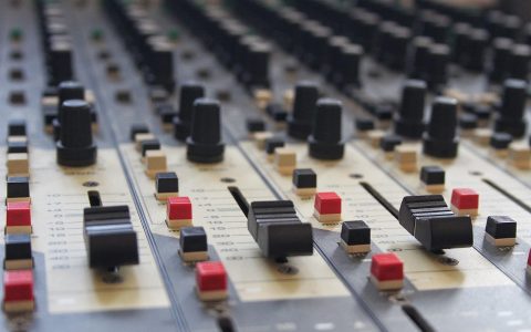 Close-up of a professional mixing console and audio interface in a recording studio