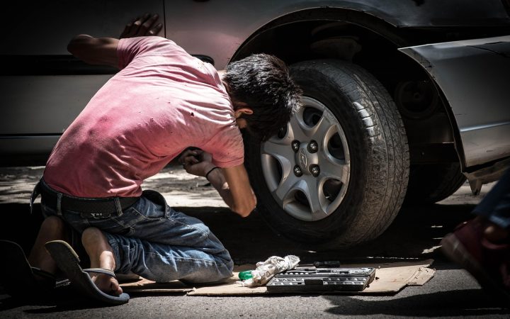 Mechanic testing a car battery in a bright workshop