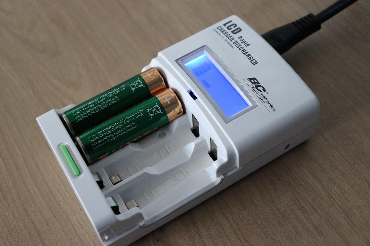 An electric bicycle battery connected to a charger on a workbench.