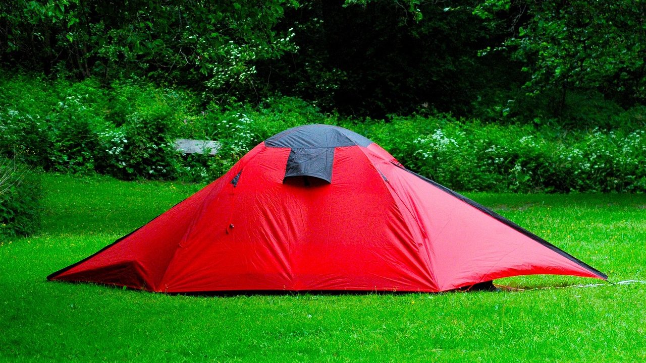 A vehicle outfitted with an aluminum hard-shell roof top tent parked at a scenic overlook during a camping trip.