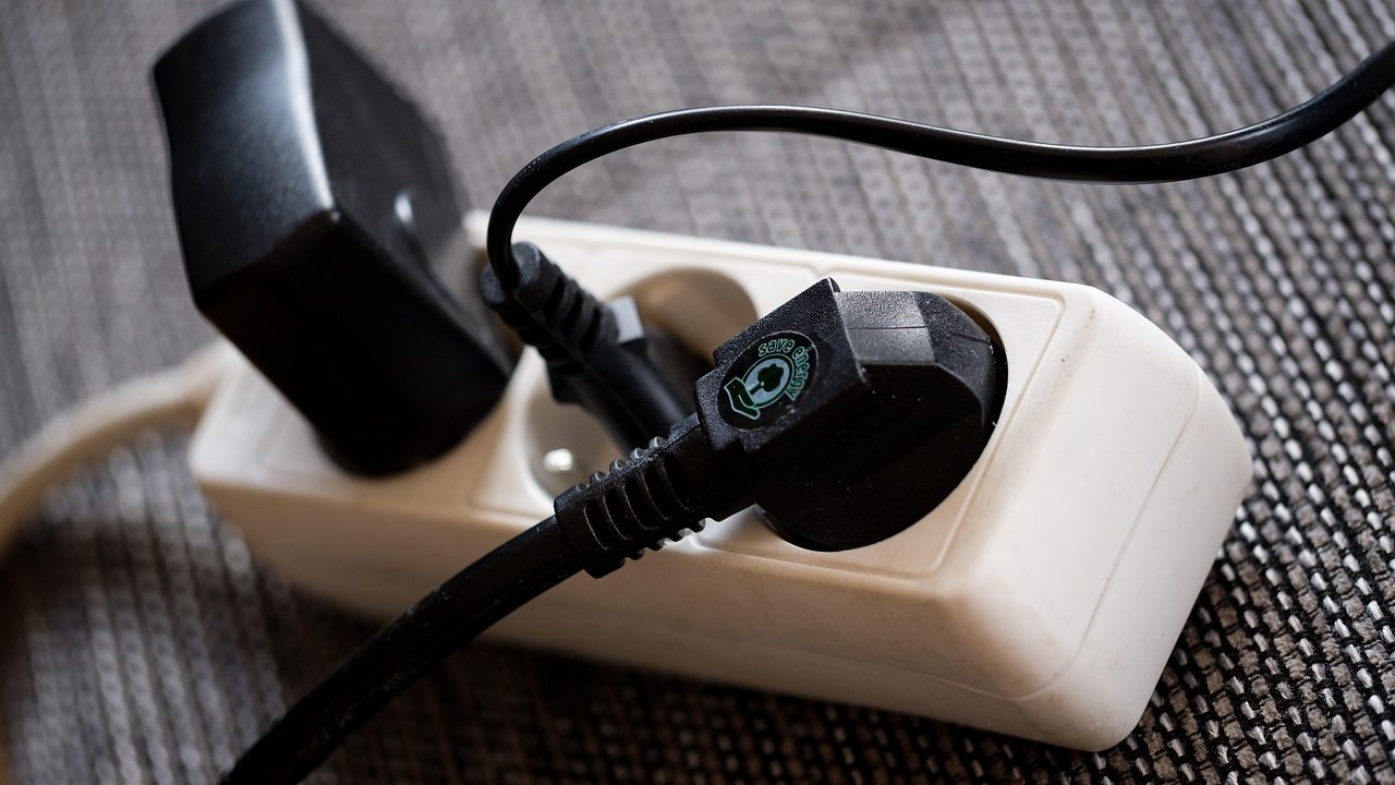 Power strip surge protector plugged into a wall outlet in an office.