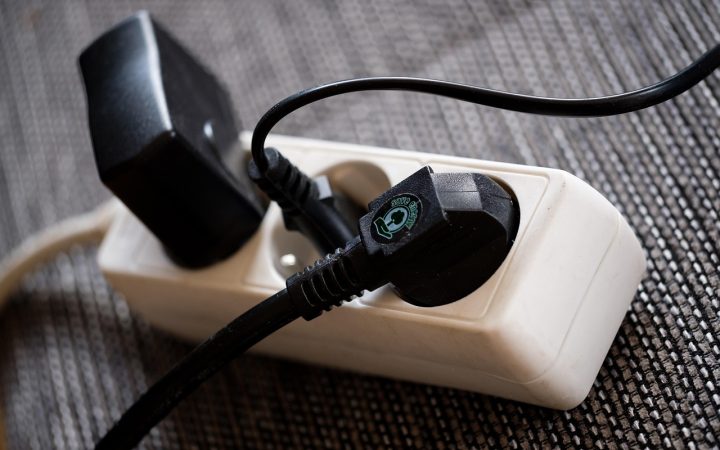 Power strip surge protector plugged into a wall outlet in an office.