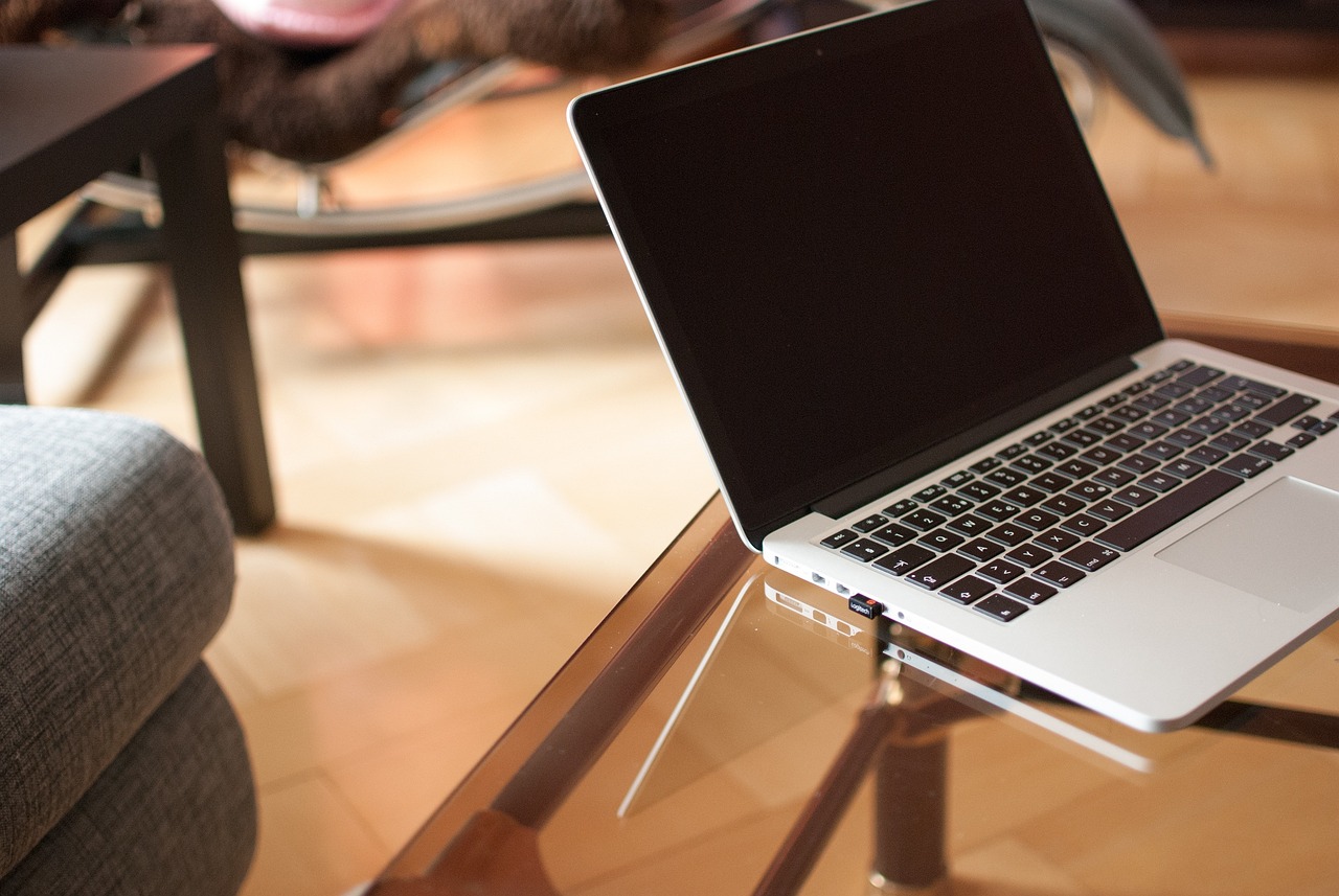An open laptop displaying a clean text editor on a wooden table.