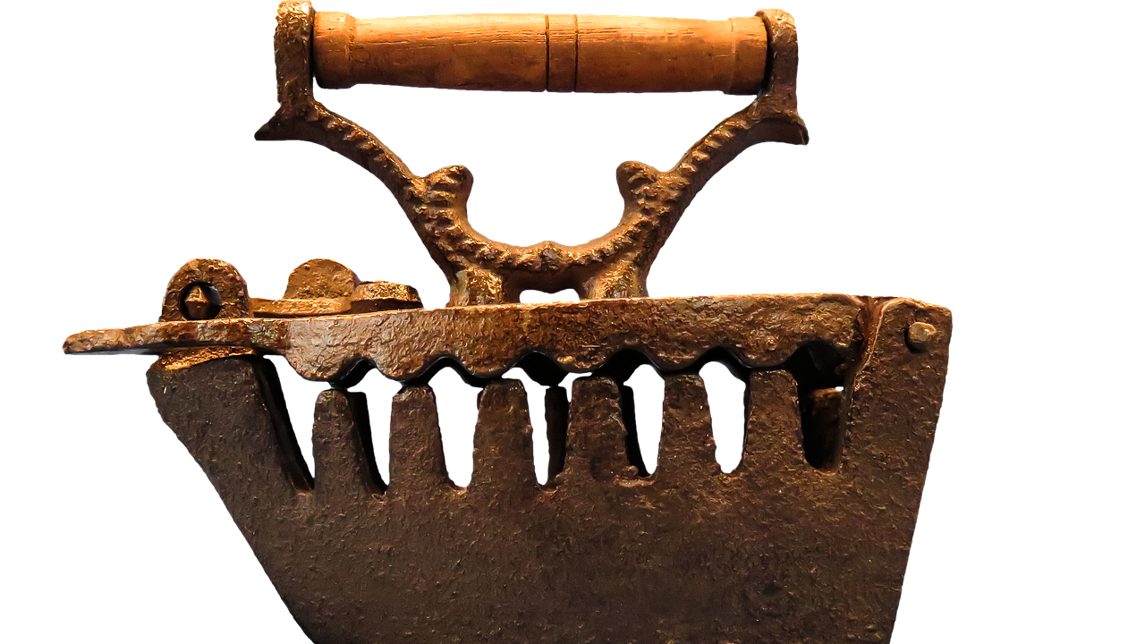 Close-up of a hand adjusting a valve on a classic cast-iron radiator.