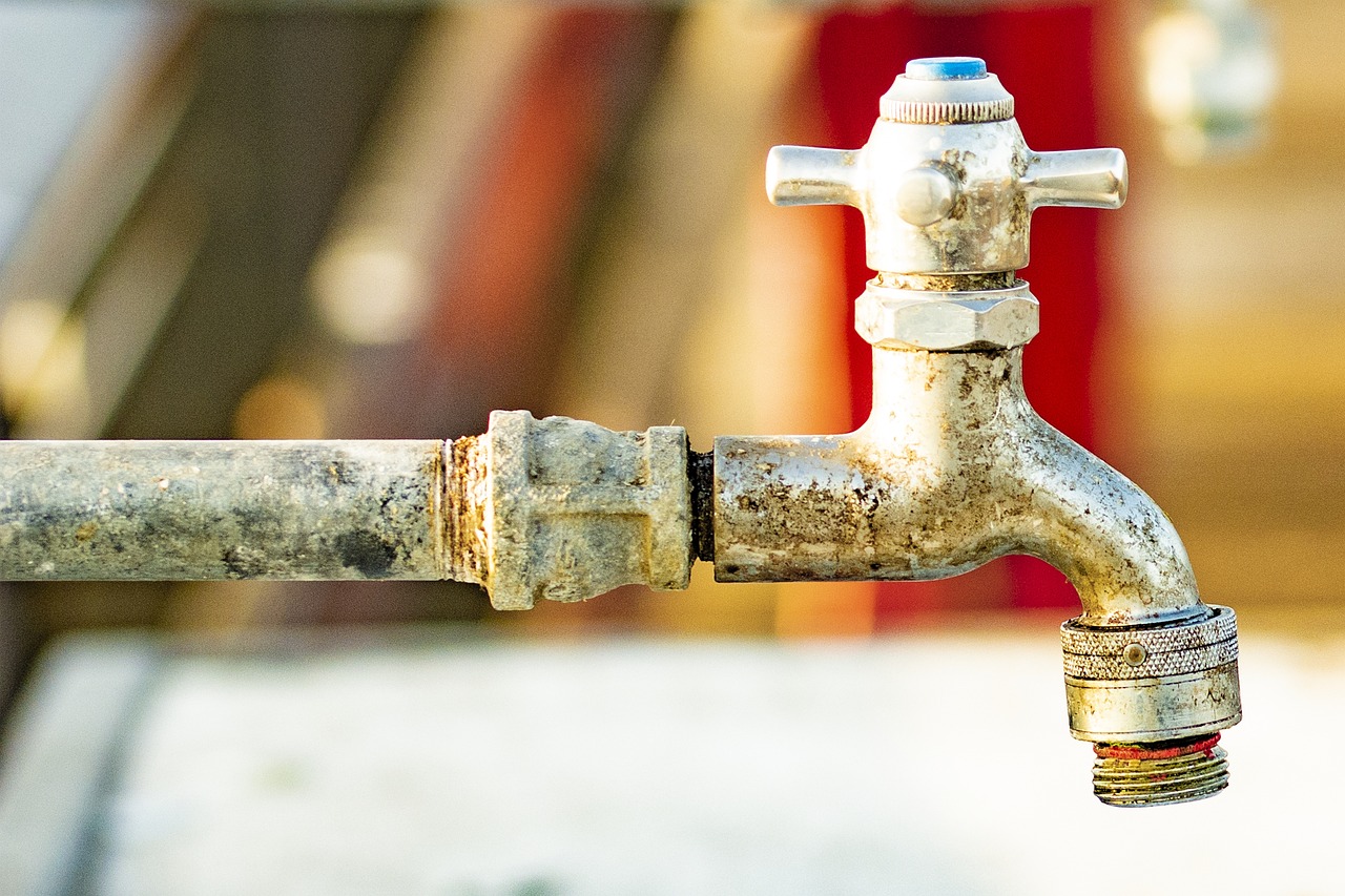 Close-up of hands adjusting brass check valves on a domestic water line.