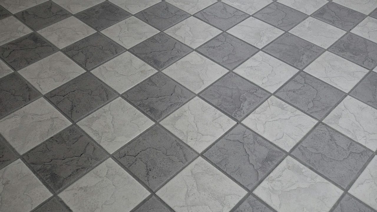 Contractor using a tape measure on a kitchen floor before tile installation
