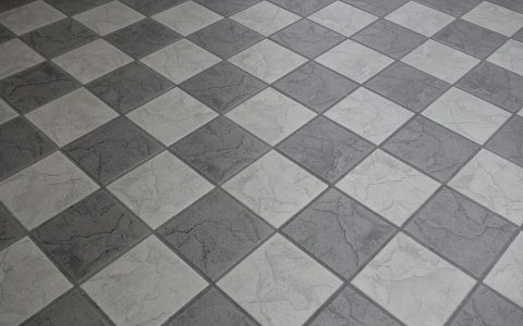 Contractor using a tape measure on a kitchen floor before tile installation