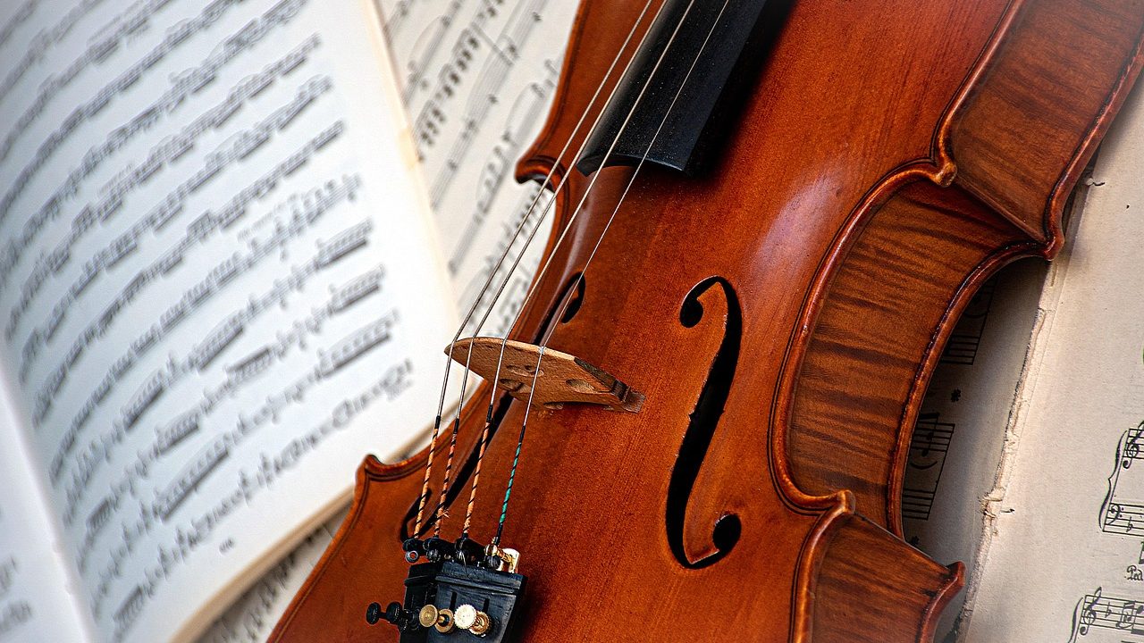 High school student playing violin in a youth orchestra rehearsal