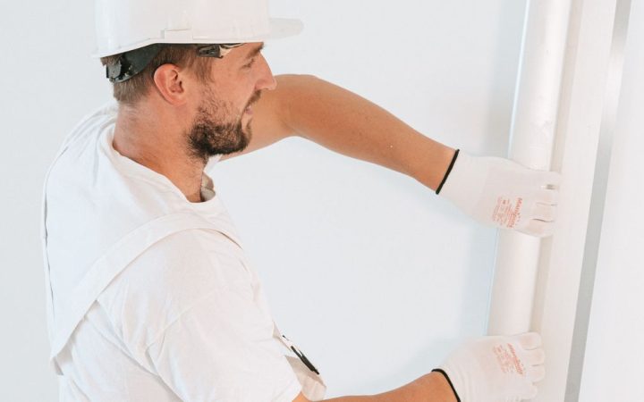 Close-up of hands tightening a metal desk clamp on a felt acoustic desktop screen.