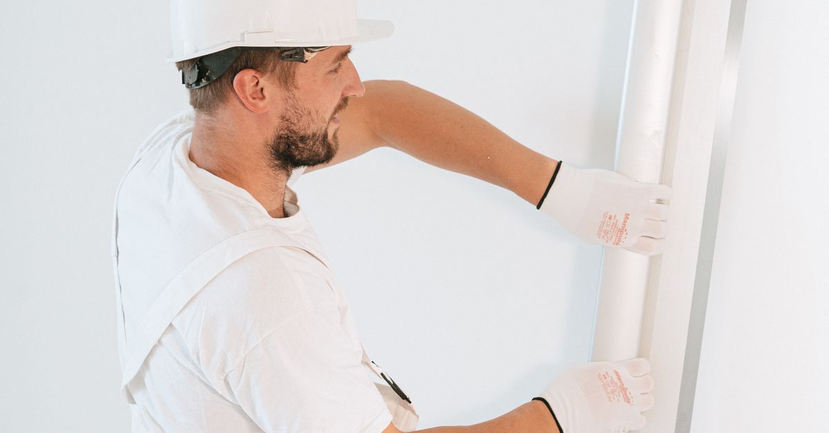 Close-up of hands tightening a metal desk clamp on a felt acoustic desktop screen.