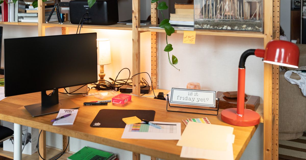 Adjustable LED desk lamp illuminating a workspace without causing screen reflections