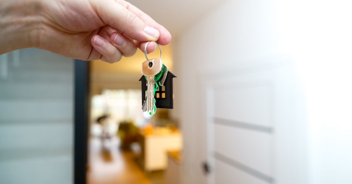 A prospective tenant holding keys inside a new apartment.