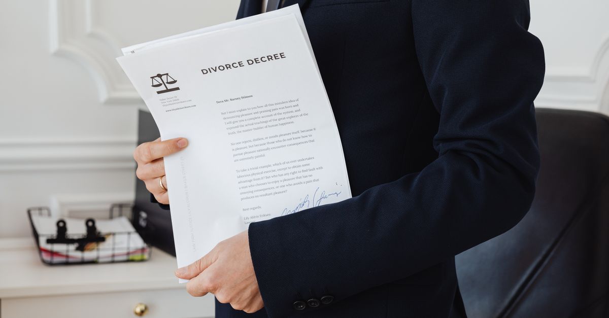 Person reviewing legal forms and demand letters at a wooden desk
